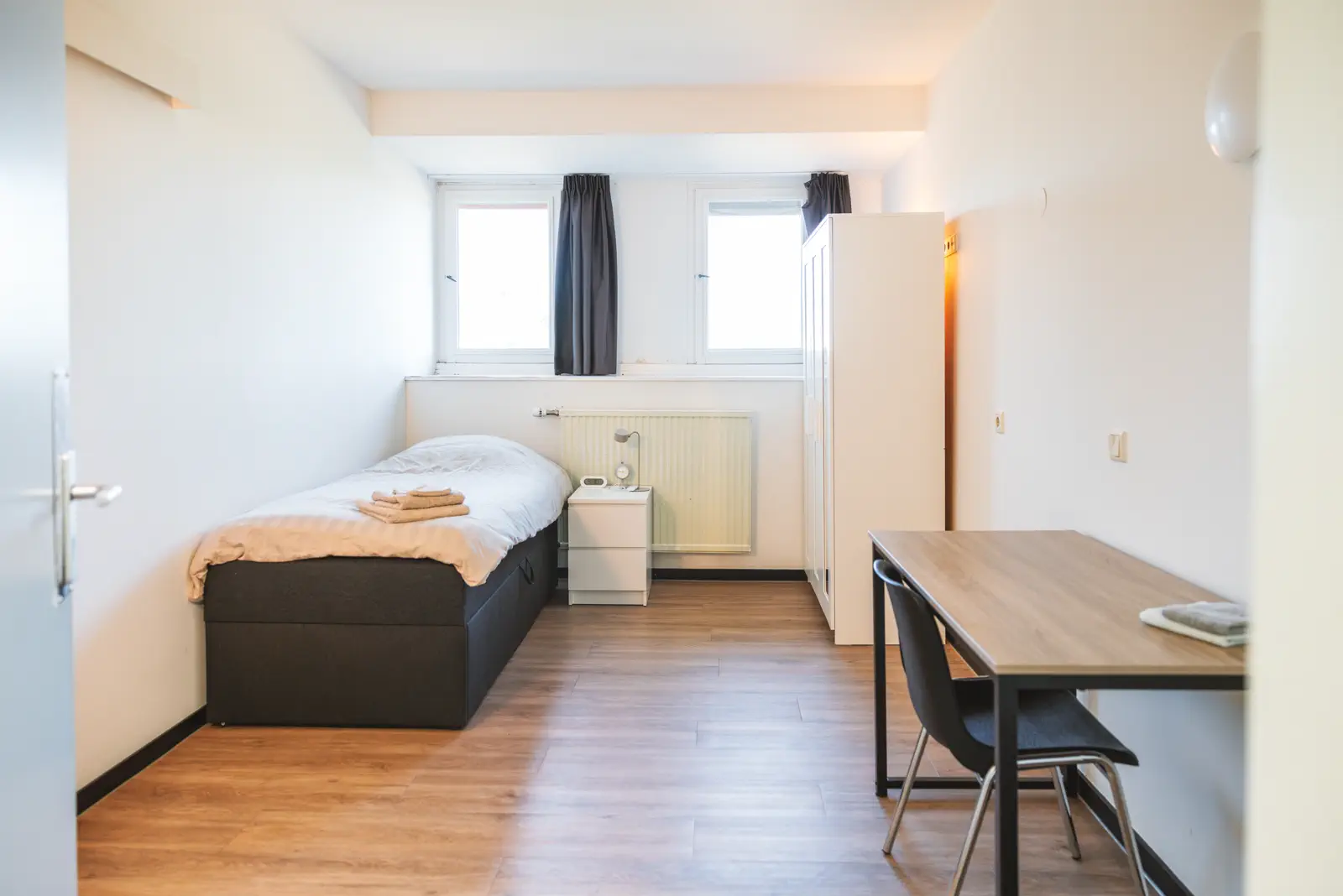 Slaapkamer met bed, bureau en stoel
